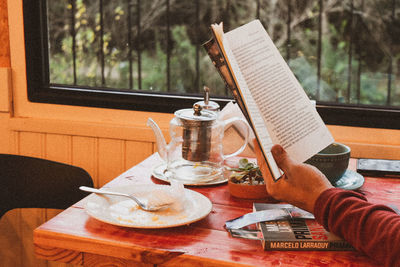 Person holding glass of table