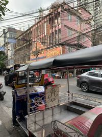 Vehicles on road by buildings in city