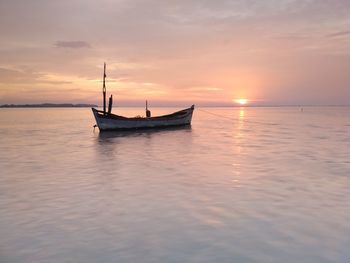 Sailboat on sea against sky during sunset