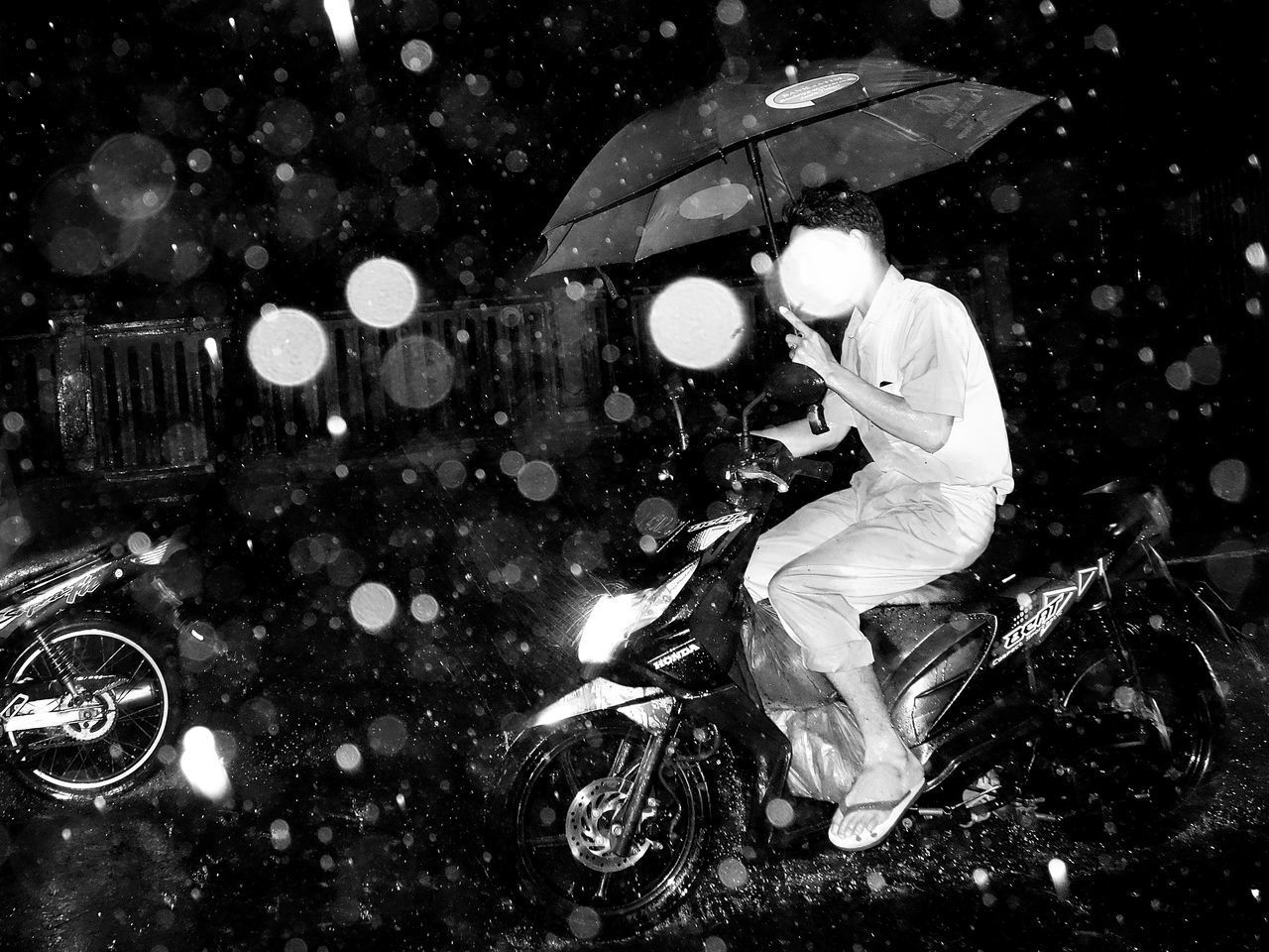 REFLECTION OF MAN ON WET STREET IN RAIN