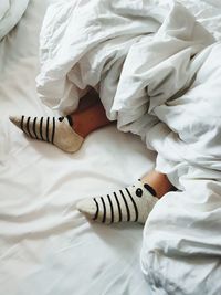 Low section of child sleeping on bed