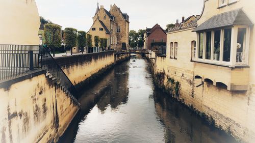 Bridge over river amidst buildings in city