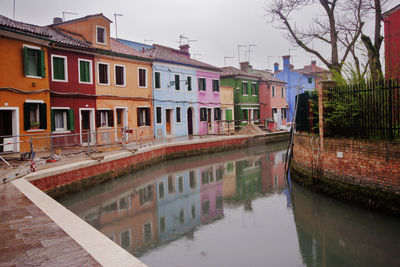 Canal amidst buildings against sky