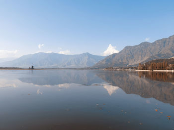 Scenic view of lake by mountains against sky