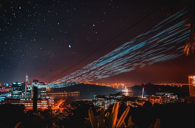 Illuminated cityscape against sky at night