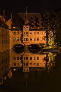 High angle view of illuminated buildings by river at night