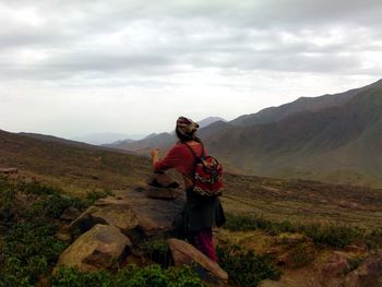 Man standing on mountain against sky