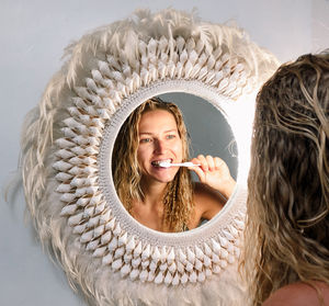 Portrait of a smiling young hipster  woman brushing her teeth 