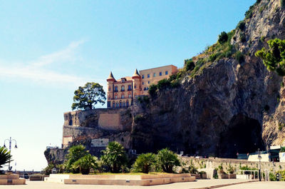 Low angle view of building on mountain against sky