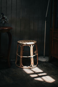 Empty stool by wall in darkroom