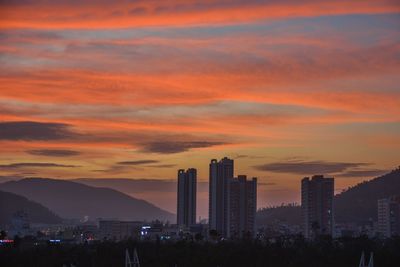 View of cityscape against cloudy sky during sunset