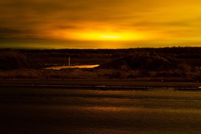 Scenic view of dramatic sky over land during sunset