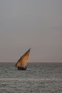 Sailboat on sea against sky during sunset