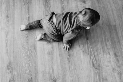 High angle view of boy lying on hardwood floor