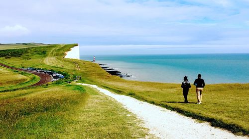 People on sea shore against sky