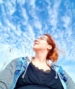 Portrait of beautiful young woman against sky