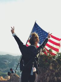 Woman standing on mountain against sky