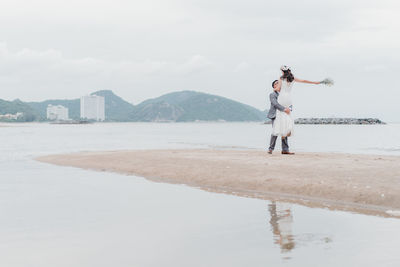 Full length of man standing on beach against sky