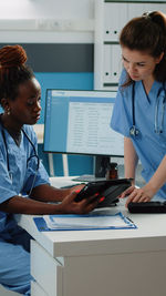 Nurse and doctor looking at digital tablet in clinic