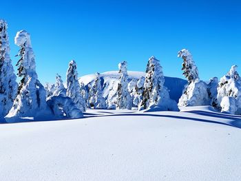 Panoramic view of snowcapped mountains against clear blue sky