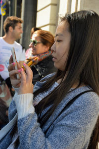 Side view portrait of a young woman holding camera