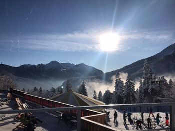 People on mountains against bright sun