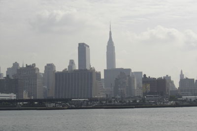 Modern buildings in city against cloudy sky