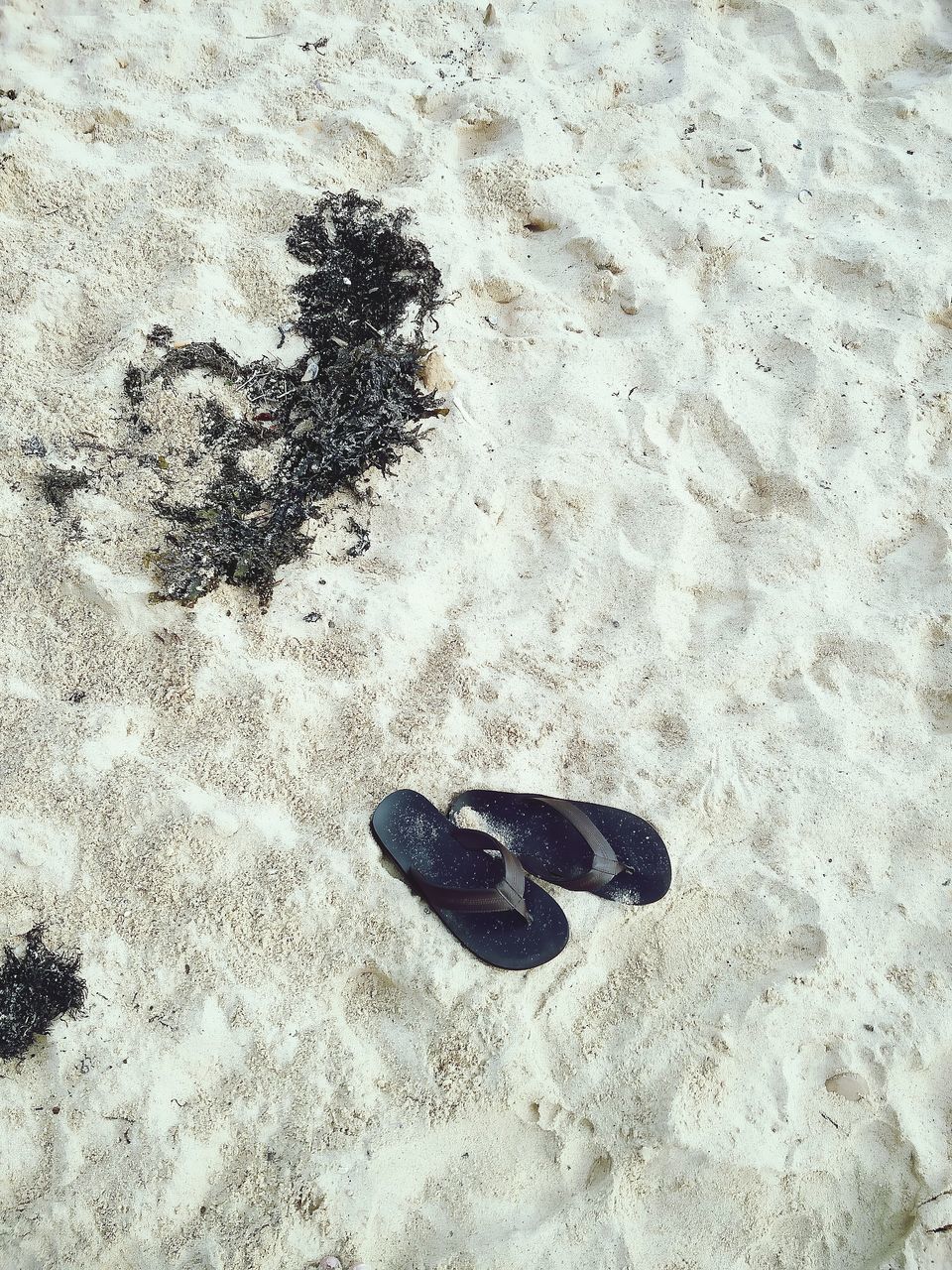 HIGH ANGLE VIEW OF FOOTPRINTS ON SANDY BEACH