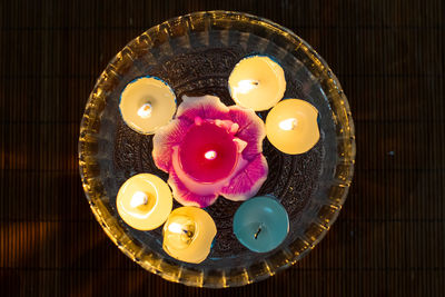 High angle view of multi coloured candles in bowl on table