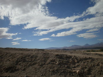Scenic view of mountains against cloudy sky