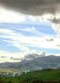 Scenic view of mountains against cloudy sky