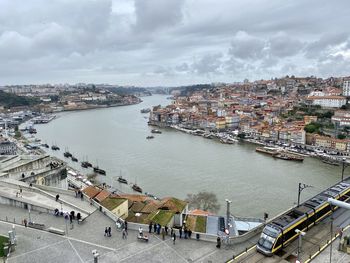 High angle view of buildings by river against sky