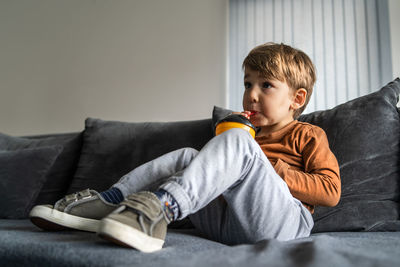 Portrait of boy sitting on sofa at home