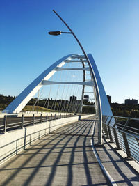 View of footbridge against clear blue sky