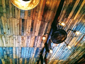 Low angle view of illuminated light bulb hanging on ceiling