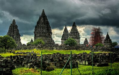 View of green landscape against cloudy sky