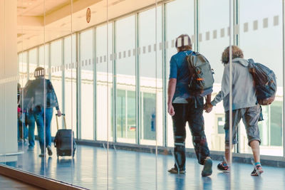 Rear view of people walking in airport building