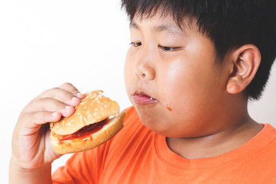 Close-up of boy looking away against white background