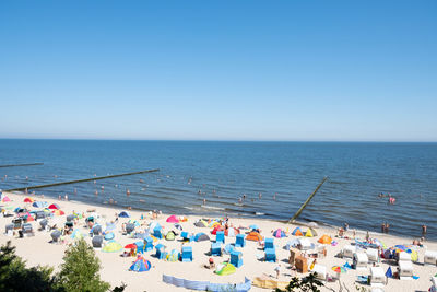 High angle view of people at beach against clear sky