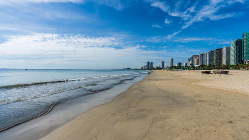 Scenic view of beach against sky in city