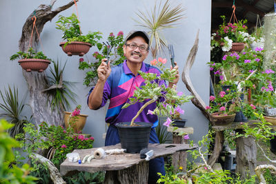 Woman standing by potted plants