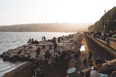 People on beach against clear sky