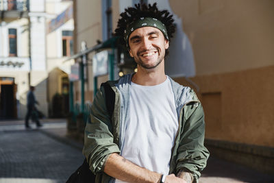 Portrait of smiling young man standing on street