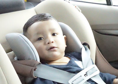 Portrait of cute girl sitting in car