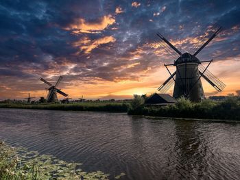 Scenic view with windmills against sky during sunset