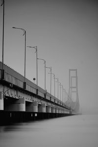 Bridge over sea against clear sky