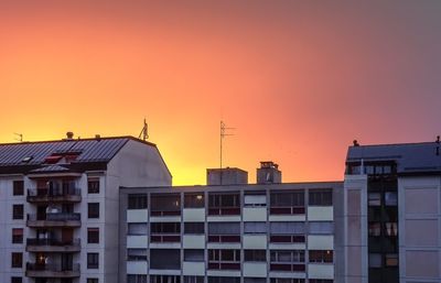 Residential buildings against sky during sunset