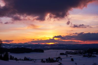 Scenic view of snowcapped landscape against sky during sunset