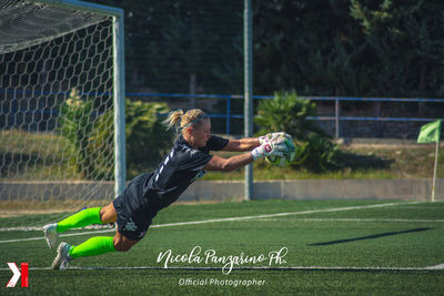 Woman playing soccer ball on grass