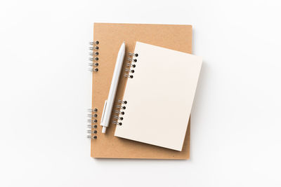 Directly above shot of spiral notebooks against white background
